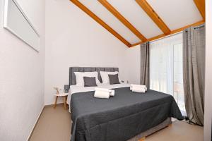 a bedroom with a large bed with two towels on it at apartmani sukošan in Sukošan
