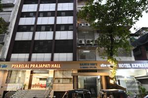 a building with two cars parked in front of it at Hotel Express Airoli in Navi Mumbai
