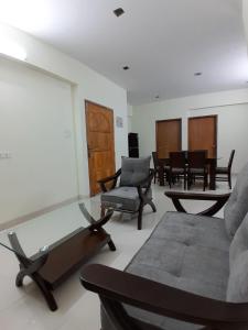 a living room with a couch and a table and chairs at Chiakunja in Dhaka