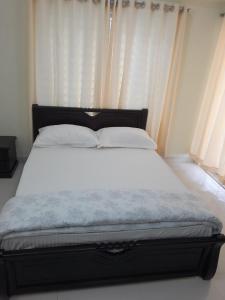 a bed with white sheets and pillows in a bedroom at Chiakunja in Dhaka