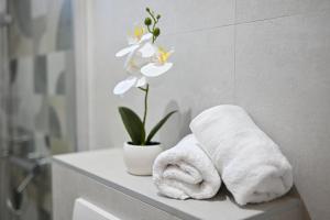 a bathroom with towels on a counter with a flower at apartmani sukošan in Sukošan +59 photos