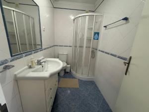 a bathroom with a sink and a shower at Peniche Surf & Sunset House in Peniche +32 photos