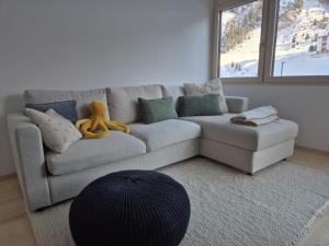 a living room with a couch with a teddy bear on it at Hemmile - Ferienwohnung in Lech in Lech am Arlberg +20 photos