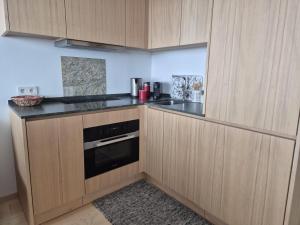 a kitchen with wooden cabinets and a stove top oven at Hemmile - Ferienwohnung in Lech in Lech am Arlberg