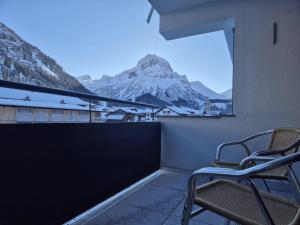 a balcony with chairs and a view of a mountain at Hemmile - Ferienwohnung in Lech in Lech am Arlberg