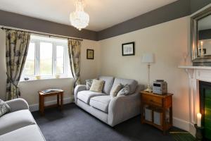 a living room with a couch and a fireplace at Reddivallen Farmhouse in Boscastle