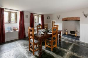 a dining room with a table and a fireplace at Reddivallen Farmhouse in Boscastle
