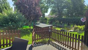 a wooden fence in a garden with a pond at Ferienwohnung "Christina" in Steinkirchen