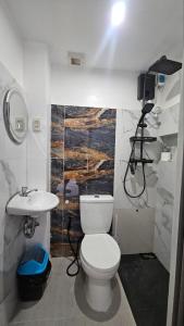 a bathroom with a white toilet and a sink at Fab's Spot El Nido in El Nido
