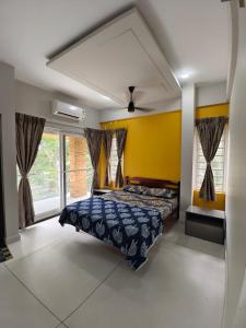 a bedroom with a bed and a yellow wall at G10 & 12 - Sabari Enclave Premium One bedroom Apartment in Trivandrum