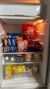 an open refrigerator filled with food and snacks at Homestay Sani in Tanah Merah