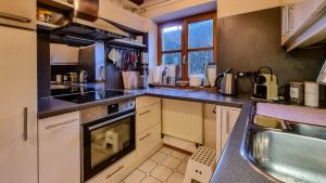 a kitchen with a sink and a stove top oven at Villa With Split-Level Architecture By Ammersee in Hechenwang