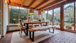 a dining room with a table and chairs and windows at Villa With Split-Level Architecture By Ammersee in Hechenwang