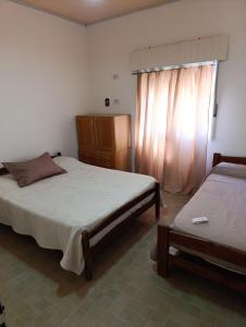 a bedroom with two beds and a window at LaLeLa in Gualeguaychú