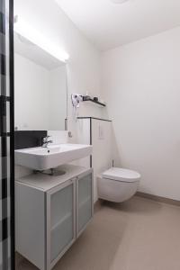 a white bathroom with a sink and a toilet at Le Carré D'Or - Chambre Calme En Hypercentre in Toulouse