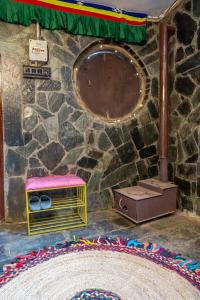 a room with a stage with a table and a rug at Mud House Entire Cottage in Dharmsāla