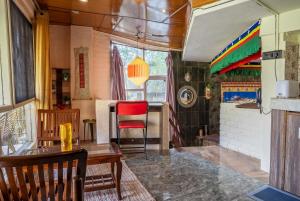a dining room with a table and a red chair at Mud House Entire Cottage in Dharmsāla +33 photos
