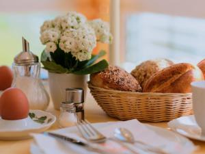 a table with a basket of bread and eggs on it at Ferienweingut-Liebfried in Nehren