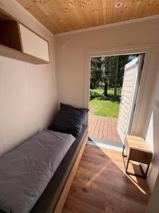 a small bedroom with a bed in a tiny house at Ferienhaus am See in Körba in Lebusa