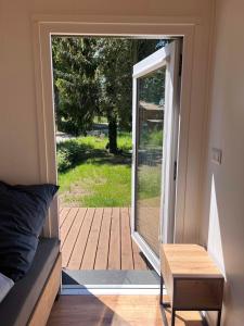 an open door to a deck with a wooden porch at Ferienhaus am See in Körba in Lebusa
