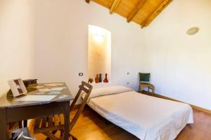 サンタンティーオコにあるAuthentic Sardinian Homeのベッドルーム1室(ベッド1台、ノートパソコン付きのデスク付)