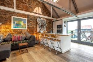 a kitchen and living room with a couch and a bar at Creewood - Elie in Elie