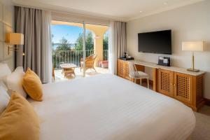 a hotel room with a bed and a television at Best Western Premier Montfleuri in Sainte-Maxime