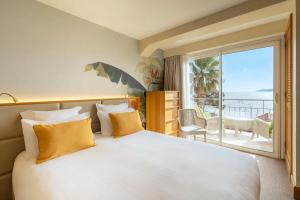 a bedroom with a large bed with a view of the ocean at Best Western Premier Montfleuri in Sainte-Maxime
