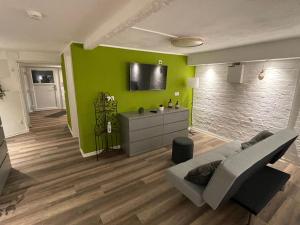 a living room with a couch and a green wall at Haus Delphinen in Lübben