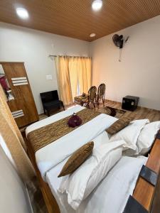a bedroom with two beds and a table and chairs at The Royal Pool Resort-Swimming Pool Resort, Varkala in Varkala