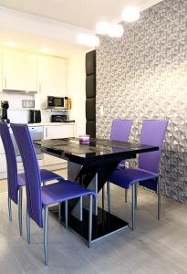 a dining room with purple chairs and a black table at Sunshine Residence Silver Apartment in Hévíz
