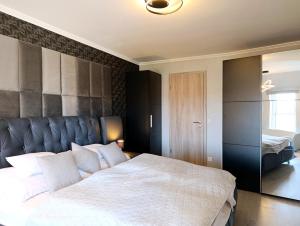 a bedroom with a large bed with white pillows at Sunshine Residence Silver Apartment in Hévíz +19 photos