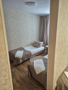 a small bedroom with two beds and a mirror at Leśna Przystań in Iława