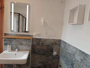 a bathroom with a sink and a mirror at Kastanienhof Lübben in Lübben