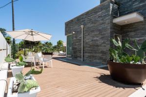 a wooden deck with plants and an umbrella at Borgo Dei Cedri in Bari