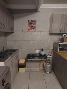 a small kitchen with a stove and a microwave at Tenlet guesthouse in Pretoria