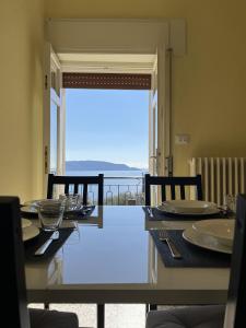 a dining room with a table and a view of the ocean at La vista dal borgo in Toscolano Maderno
