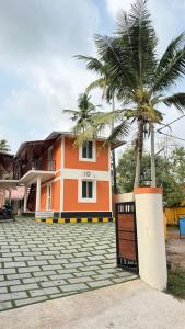 a house with a palm tree in front of it at The Royal Pool Resort-Swimming Pool Resort, Varkala in Varkala