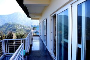 a balcony of a house with a view of the mountains at Serenidad- The Cottage in Mukteshwar