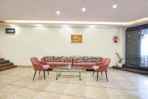 a living room with a couch and two chairs and a table at Via Lazeeno in Faridabad