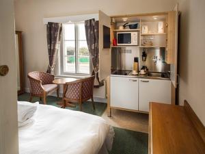 a room with a bed and a kitchen and a table at Albert and Victoria Hotel in Southport