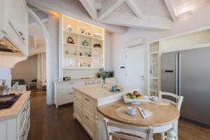 a large kitchen with a table and a refrigerator at Villa Lilla sulla Spiaggia di San Vincenzo LUXURY in San Vincenzo