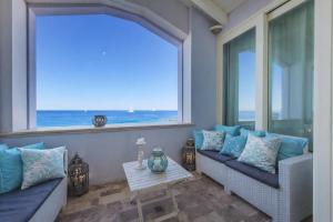 a room with two couches and a window with the ocean at Villa Lilla sulla Spiaggia di San Vincenzo LUXURY in San Vincenzo