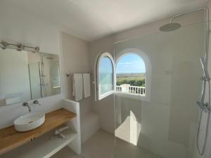 a bathroom with a sink and a glass shower at Menorca Villa Fenicia in Son Parc +34 photos