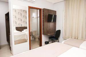 a bedroom with a mirror and a bed and a chair at Premier Pallace Hotel in Araguaína +42 photos