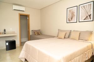 a bedroom with a large white bed and a couch at Vinícola Villa Aurum in Corumbá de Goiás +13 photos
