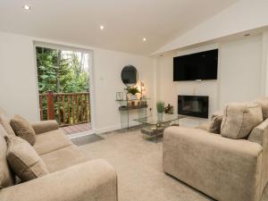 a living room with two couches and a fireplace at Mere Brook Lodge in Windermere