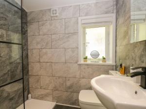 a bathroom with a sink and a toilet at Mere Brook Lodge in Windermere +14 photos