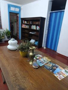 a wooden table with a vase and magazines on it at La mansion caballero hostal in Asunción
