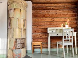a desk and chair next to a wooden wall at Ahtelan torppa 1 in Salo